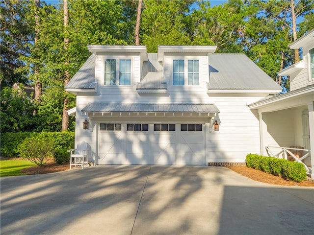 904 Champney, Saint Simons Island, GA 31522 - view of front of house featuring concrete driveway, an attached garage, and a metal roof