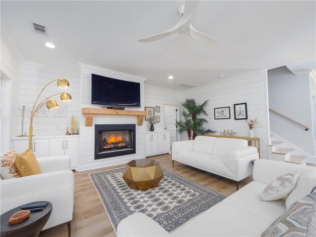 904 Champney, Saint Simons Island, GA 31522 - living area with ornamental molding, a warm lit fireplace, wood walls, stairs, and recessed lighting