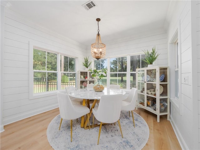 904 Champney, Saint Simons Island, GA 31522 - dining room with a chandelier, light wood-style flooring, and wood walls