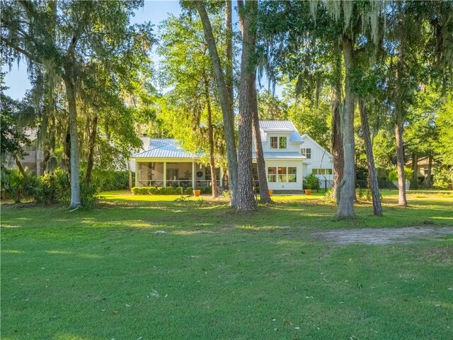 904 Champney, Saint Simons Island, GA 31522 - view of front of house with a front yard and a metal roof