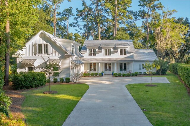 904 Champney, Saint Simons Island, GA 31522 - view of front of home featuring covered porch, a front yard, board and batten siding, and concrete driveway