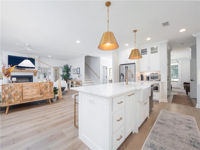904 Champney, Saint Simons Island, GA 31522 - kitchen with open floor plan, light wood-type flooring, stainless steel appliances, recessed lighting, and white cabinets