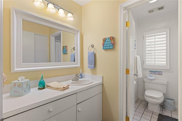 bathroom featuring tile patterned flooring, vanity, and toilet