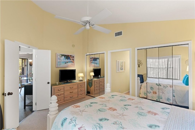 bedroom featuring ceiling fan, a closet, light colored carpet, and vaulted ceiling