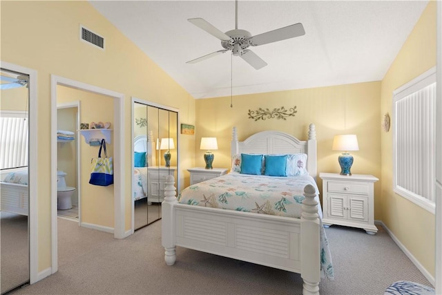 carpeted bedroom with ceiling fan, a closet, ensuite bathroom, and vaulted ceiling