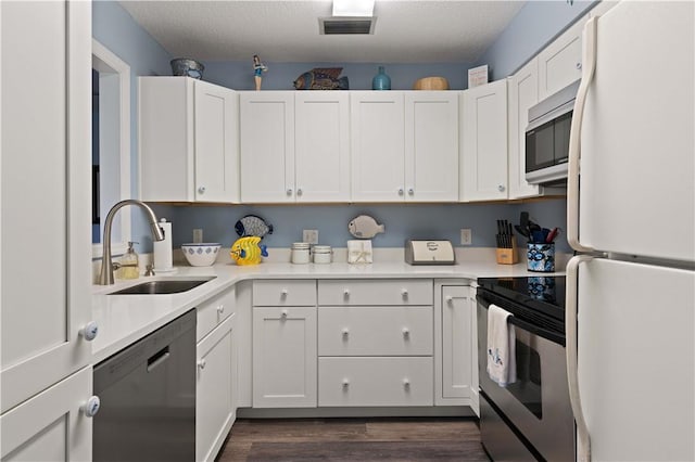 kitchen featuring a textured ceiling, stainless steel appliances, white cabinetry, and sink