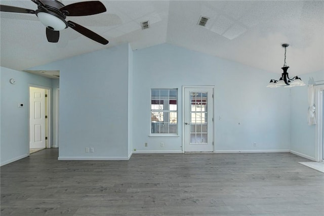 spare room featuring ceiling fan with notable chandelier, vaulted ceiling, and hardwood / wood-style flooring