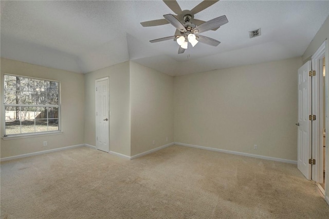 carpeted spare room with lofted ceiling and ceiling fan