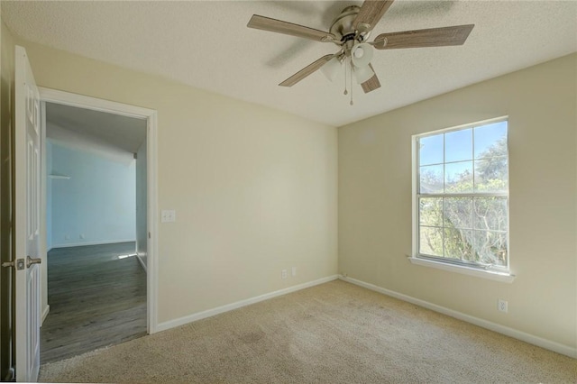 carpeted spare room with a textured ceiling and ceiling fan