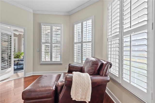 sitting room with crown molding, wood-type flooring, and plenty of natural light