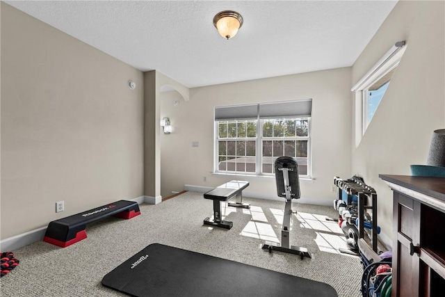 workout area featuring carpet and a textured ceiling