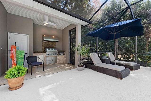 view of patio / terrace featuring ceiling fan, an outdoor kitchen, grilling area, and glass enclosure