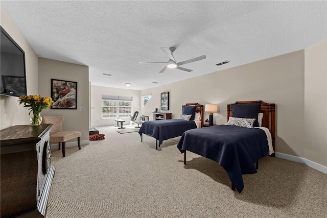 carpeted bedroom with ceiling fan and a textured ceiling