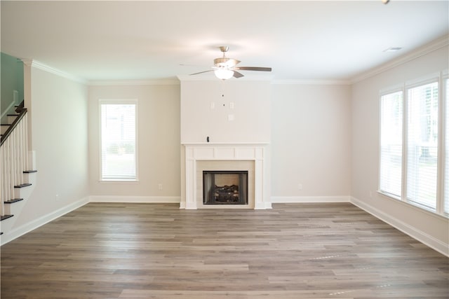 unfurnished living room featuring ceiling fan, crown molding, and wood-type flooring