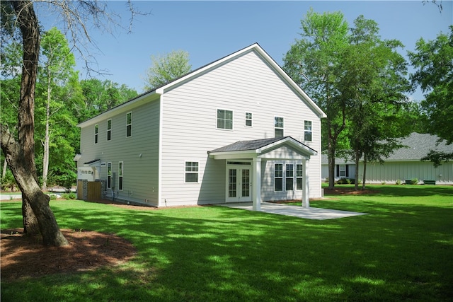 back of house with french doors, a patio area, and a lawn