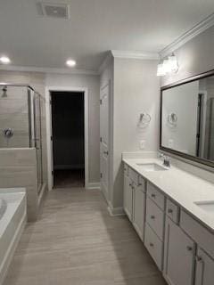 bathroom featuring crown molding, vanity, and shower with separate bathtub