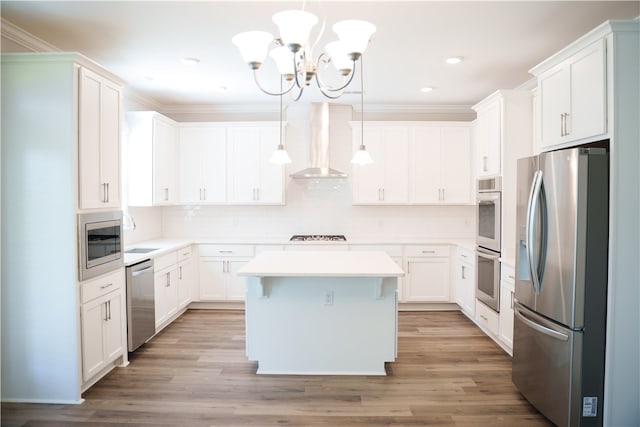 kitchen with a center island, white cabinetry, wall chimney range hood, and appliances with stainless steel finishes