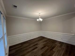 unfurnished dining area featuring dark hardwood / wood-style flooring, crown molding, and an inviting chandelier