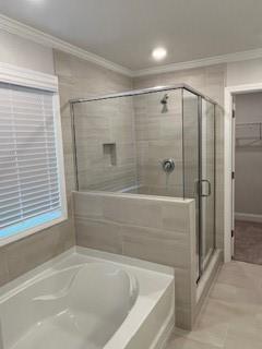 bathroom with separate shower and tub and ornamental molding