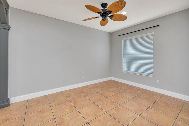 empty room with ceiling fan and light tile patterned flooring