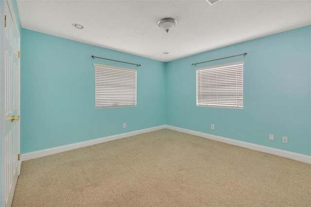 carpeted spare room featuring a healthy amount of sunlight