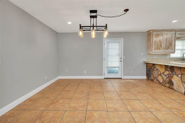 interior space featuring pendant lighting, light tile patterned floors, sink, and light brown cabinetry