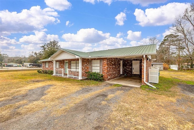 single story home featuring covered porch and a carport