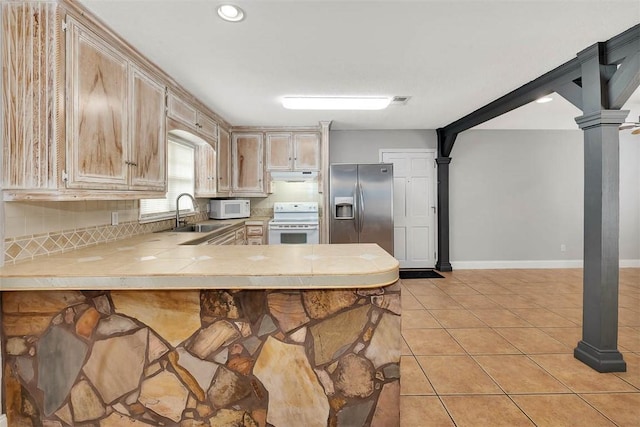 kitchen featuring sink, light brown cabinets, kitchen peninsula, white appliances, and light tile patterned floors