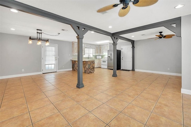 unfurnished living room featuring light tile patterned floors and ceiling fan