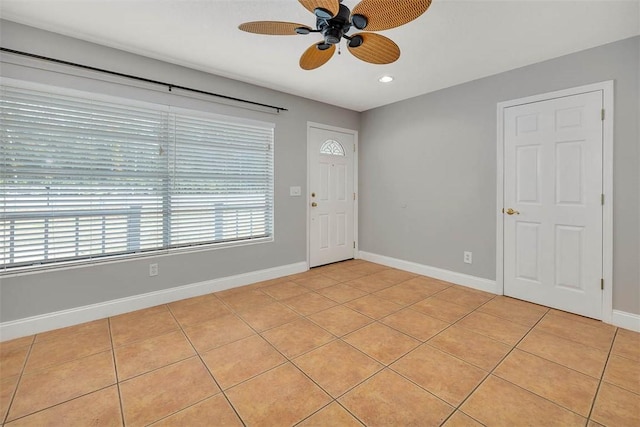 foyer entrance with ceiling fan and light tile patterned flooring