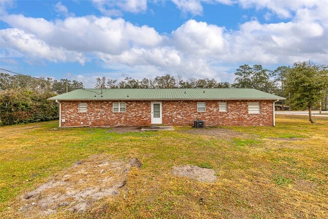 back of property featuring a yard and central air condition unit