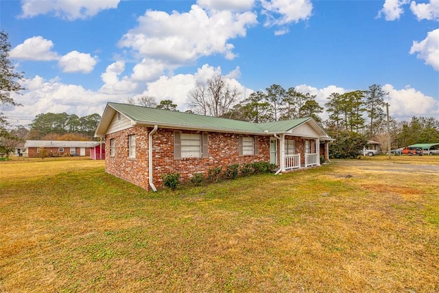 ranch-style home featuring covered porch and a front yard
