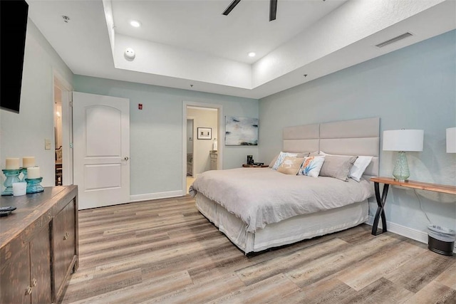 150 Salt Air Dr Unit 202, Saint Simons Island, GA 31522 - bedroom featuring a tray ceiling, light wood-type flooring, ensuite bath, recessed lighting, and ceiling fan