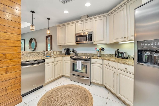 150 Salt Air Dr Unit 202, Saint Simons Island, GA 31522 - kitchen with stainless steel appliances, light tile patterned floors, hanging light fixtures, light stone countertops, and recessed lighting