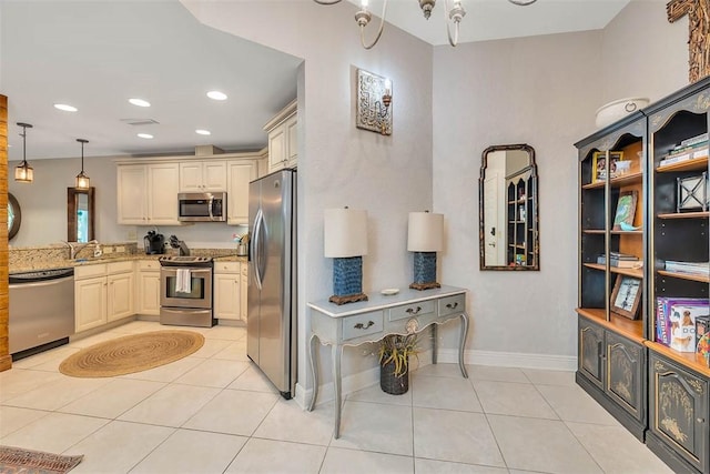 150 Salt Air Dr Unit 202, Saint Simons Island, GA 31522 - kitchen with stainless steel appliances, light tile patterned floors, light stone counters, decorative light fixtures, and recessed lighting