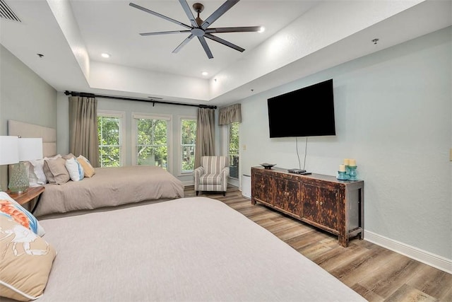 150 Salt Air Dr Unit 202, Saint Simons Island, GA 31522 - bedroom with light wood finished floors, a tray ceiling, ceiling fan, and recessed lighting