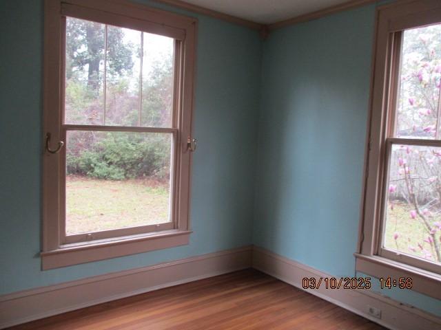 unfurnished room featuring light wood-style flooring, baseboards, and ornamental molding