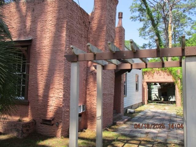 view of side of property with a pergola