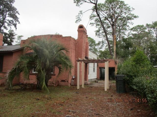 view of property exterior featuring a pergola and a chimney
