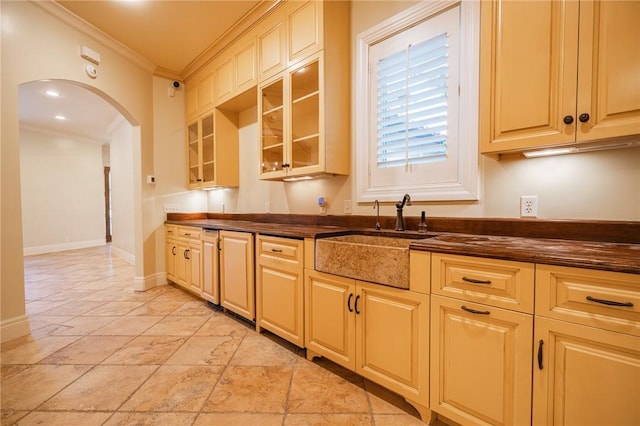 178 Hampton Point Dr, Saint Simons Island, GA 31522 - kitchen featuring crown molding, arched walkways, and glass insert cabinets
