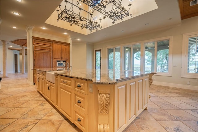 178 Hampton Point Dr, Saint Simons Island, GA 31522 - kitchen with crown molding, a kitchen island with sink, decorative columns, light stone countertops, and recessed lighting