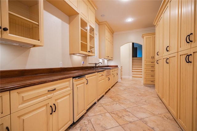 178 Hampton Point Dr, Saint Simons Island, GA 31522 - kitchen with dark countertops, arched walkways, ornamental molding, glass insert cabinets, and light stone finish floors