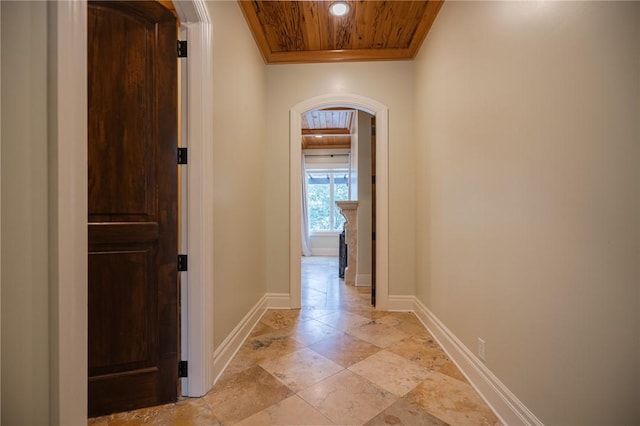 178 Hampton Point Dr, Saint Simons Island, GA 31522 - hallway with arched walkways, crown molding, wooden ceiling, and light stone finish floors