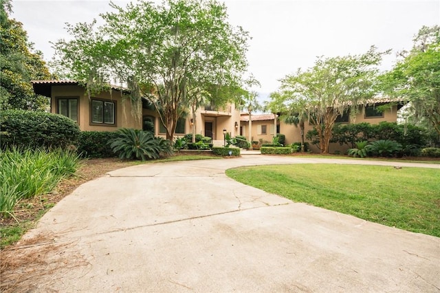 178 Hampton Point Dr, Saint Simons Island, GA 31522 - view of front of home with a front lawn, curved driveway, and stucco siding