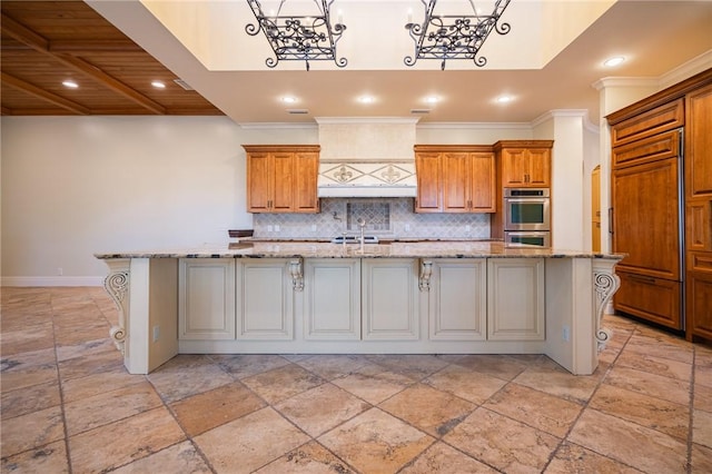178 Hampton Point Dr, Saint Simons Island, GA 31522 - kitchen featuring double oven, stone tile flooring, decorative backsplash, a large island with sink, and crown molding
