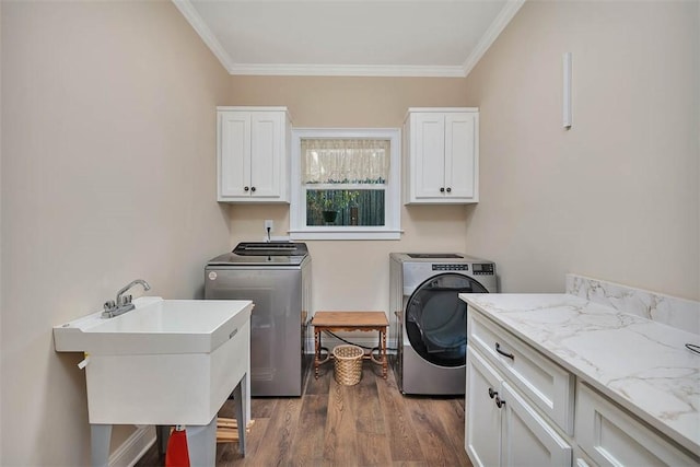 washroom with sink, cabinets, ornamental molding, washer and dryer, and dark hardwood / wood-style flooring