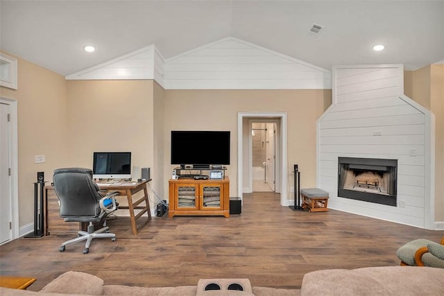 office with wood-type flooring, lofted ceiling, and a large fireplace