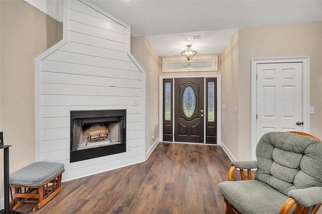 foyer entrance featuring dark hardwood / wood-style floors and a fireplace