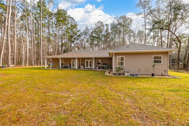 rear view of property featuring a lawn and a patio