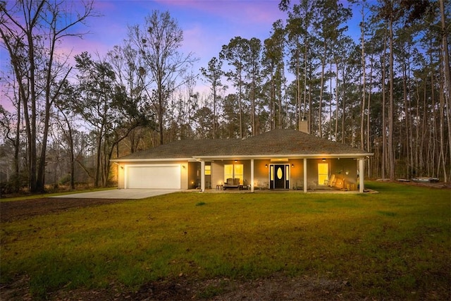 view of front facade featuring a garage, a lawn, and a porch